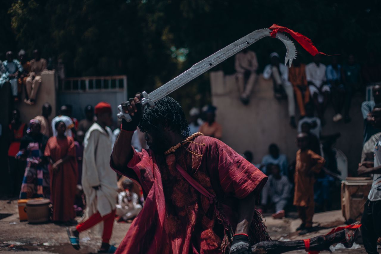 The Art of Drawing Readers In: Your attractive post title goes here Vibrant festival scene with a performer in traditional attire wielding a machete.