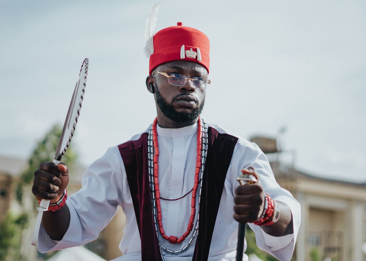 Mastering the First Impression: Your intriguing post title goes here A Nigerian man wears traditional Igbo attire, showcasing cultural heritage outdoors during the day.