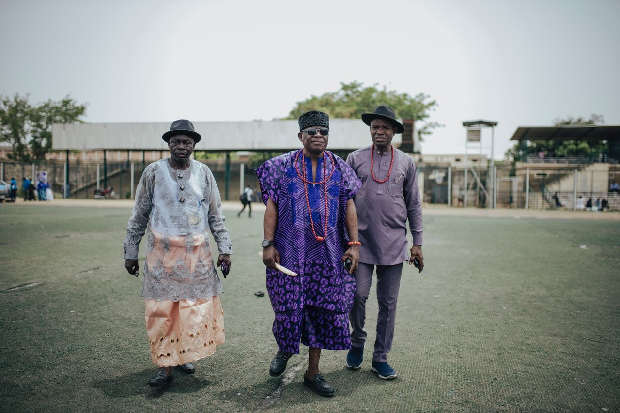 Services Three men in traditional African clothing standing outdoors, showcasing cultural attire and unity.